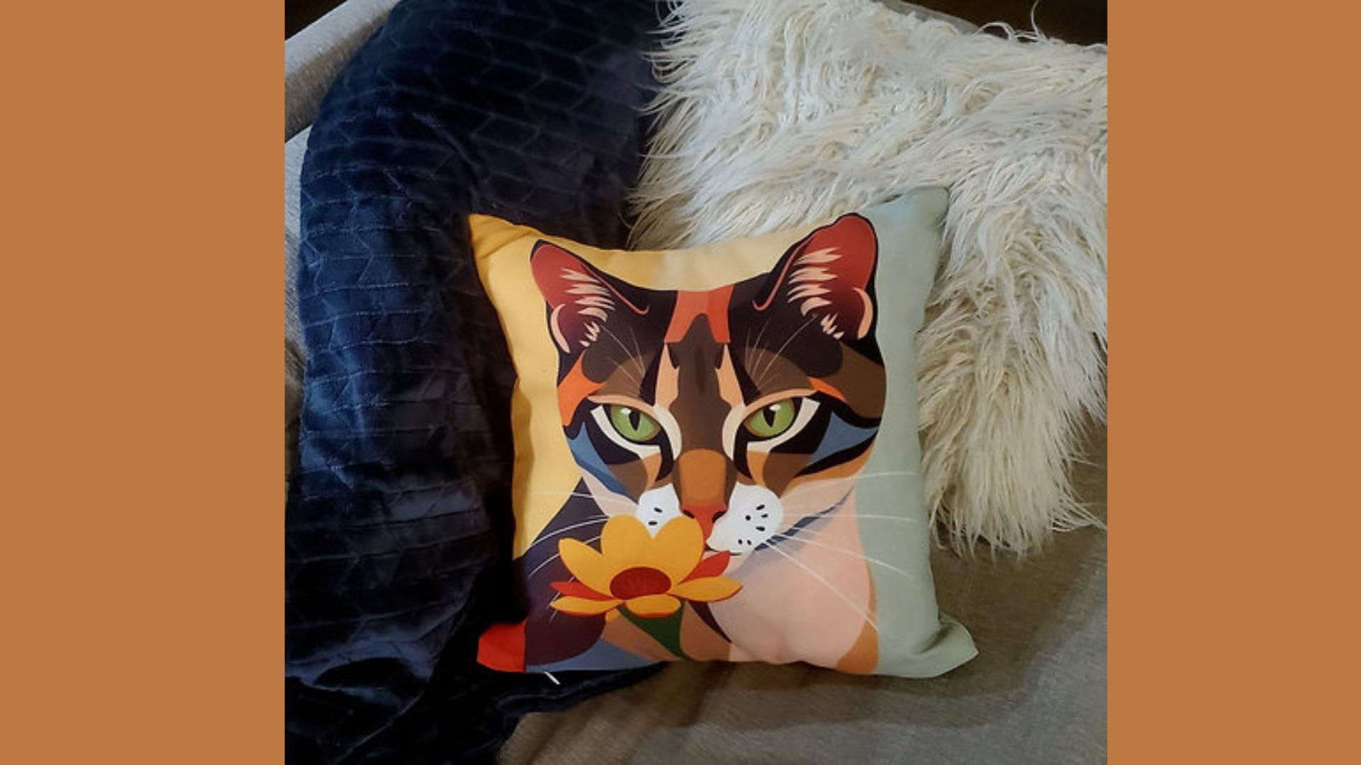 Tabby Cat and Sunflower Pillow on a sofa with a white pillow and a blue blanket
