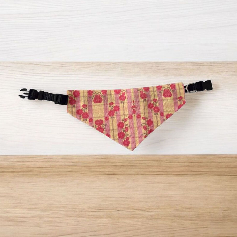 Pink floral pet bandana with striped pattern and black buckle, placed on a light wooden surface for contrast.