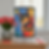Colorful cat-themed tripod lamp on a wooden table near a vase of red tulips. Bright, abstract design with blue, orange, and black tones.