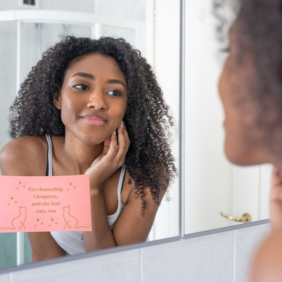 Woman Looking in Mirror with a Pink Mirror Cling