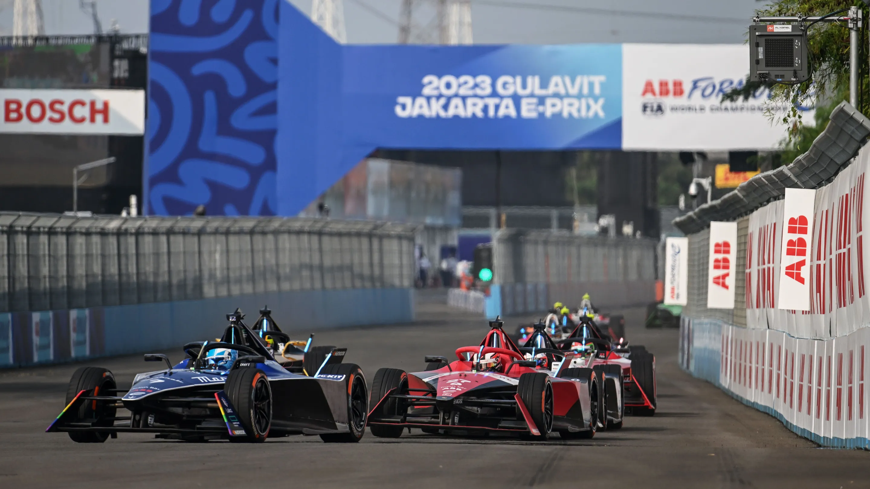 Many Formula E cars on a track at the Jakarta E-Prix