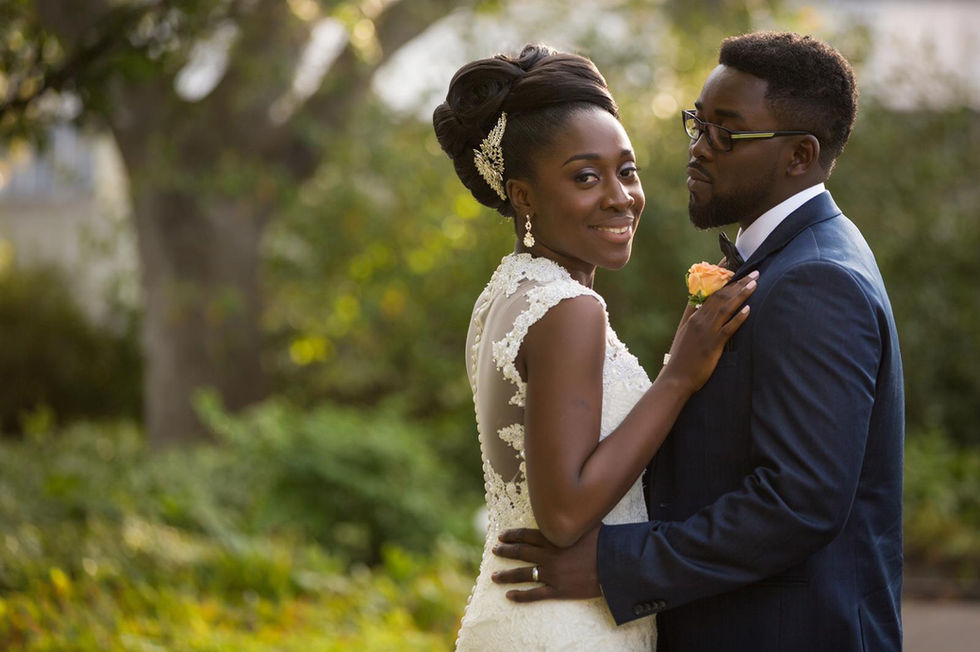 Bride and groom embracing in a garden setting.