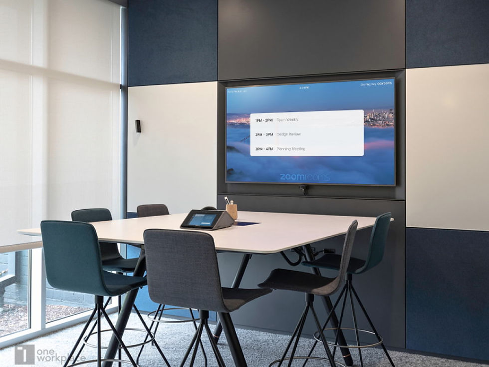 Conference room with a table, chairs, and a screen displaying meeting times: Team Weekly, Design Review, Planning Meeting. Mood is professional.