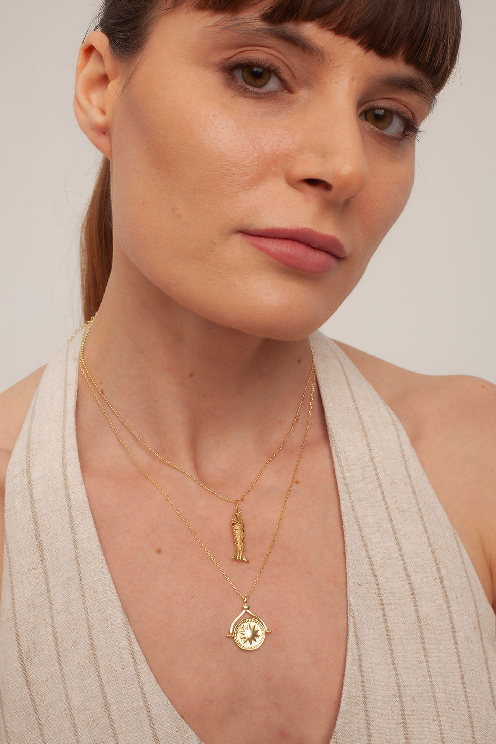 Woman wearing gold Sun & Moon Spinner Pendant necklace