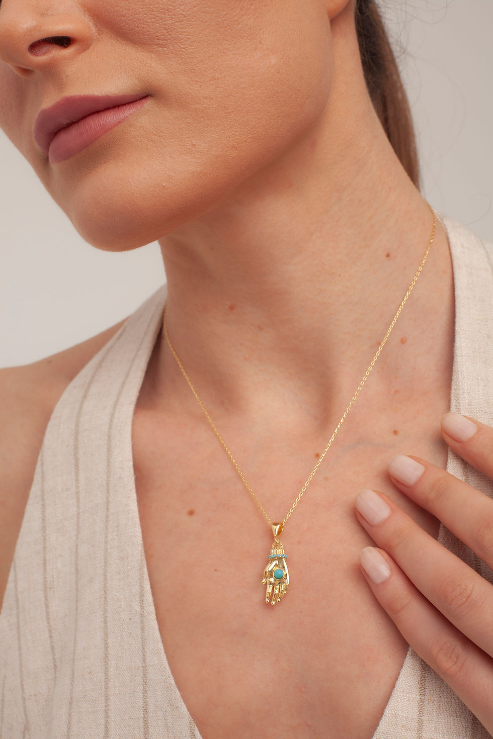 Woman wearing gold Hamsa necklace