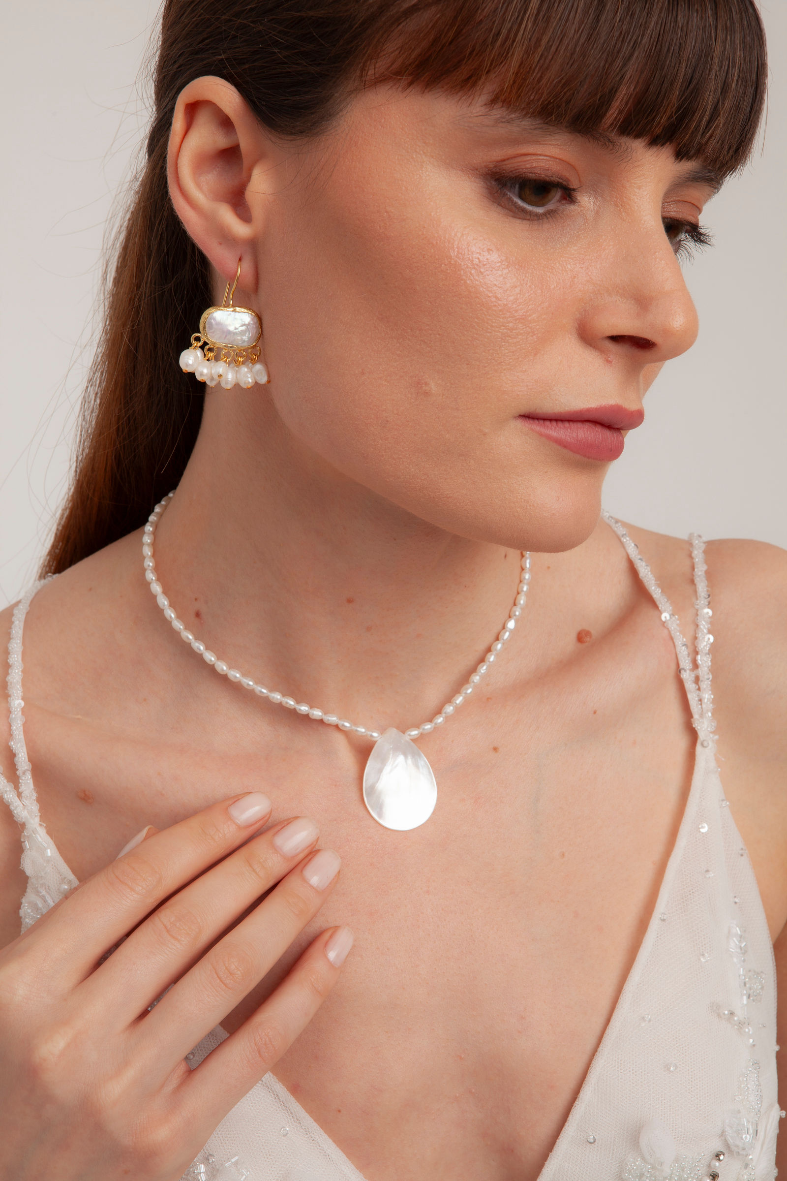 Woman wearing elegant pearl necklace and earrings