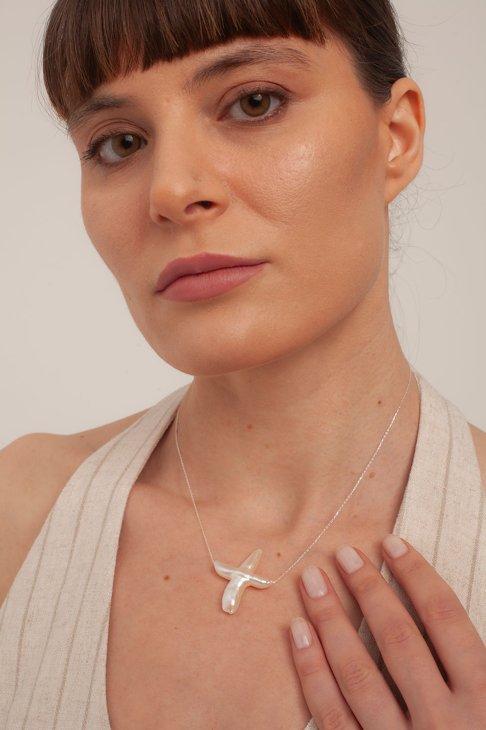Woman wearing elegant pearl starfish necklace