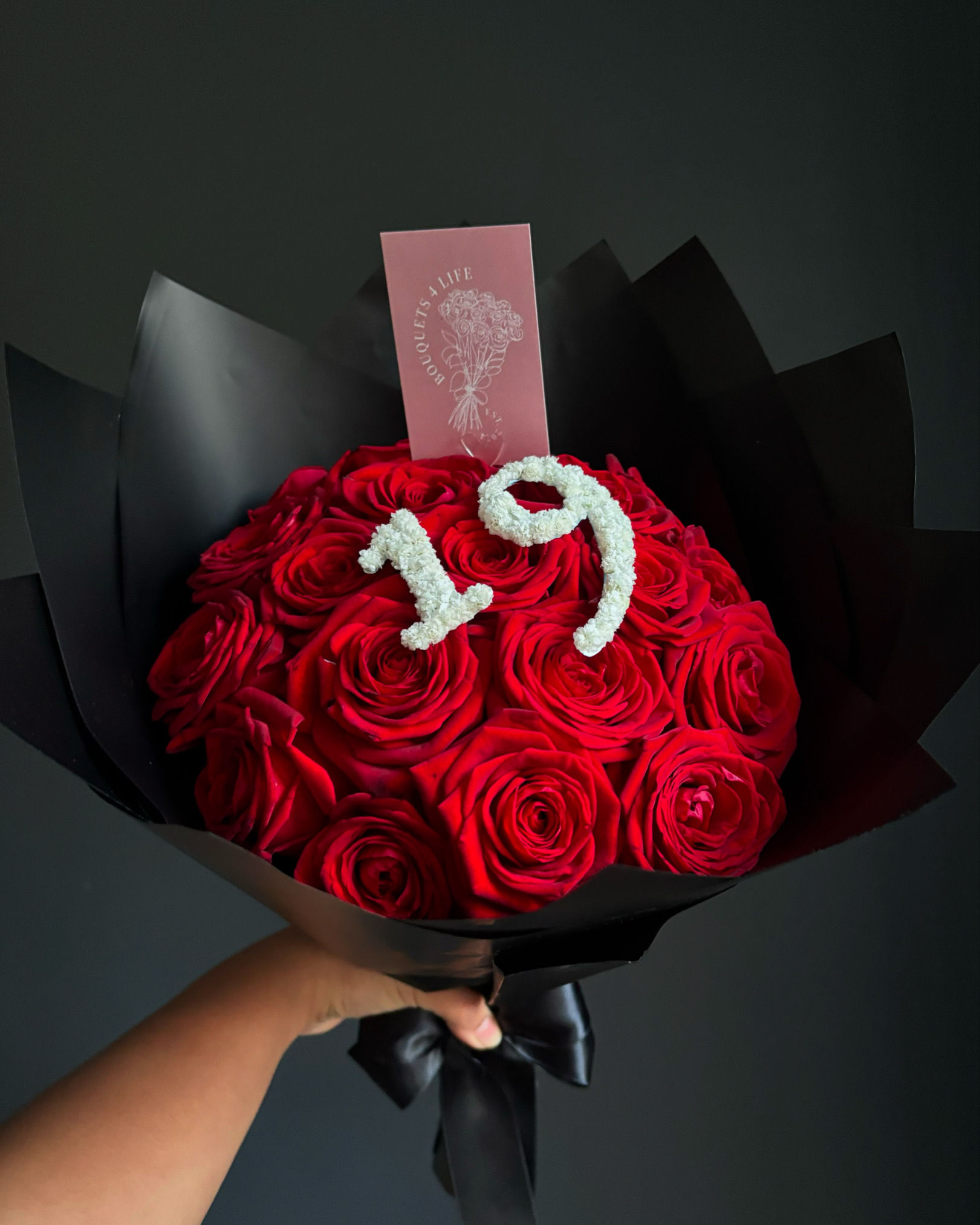 Red rose bouquet, number 19, Bouquets 4 Life, wrapped in black paper background.