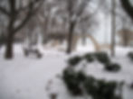 A snowy park with benches and a view of Lake Michigan