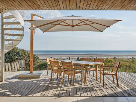 Barlow Tyrie Monterey teak dining set and parasol on a terrace