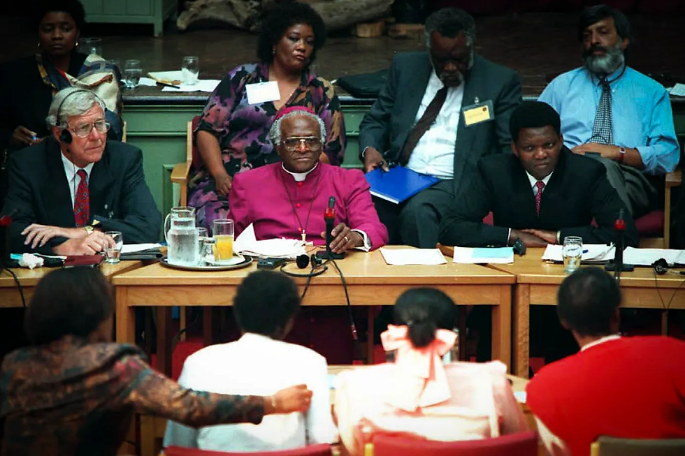 Archbishop Desmond Tutu (Center) listening to victims stories during a Truth & Reconciliation hearing