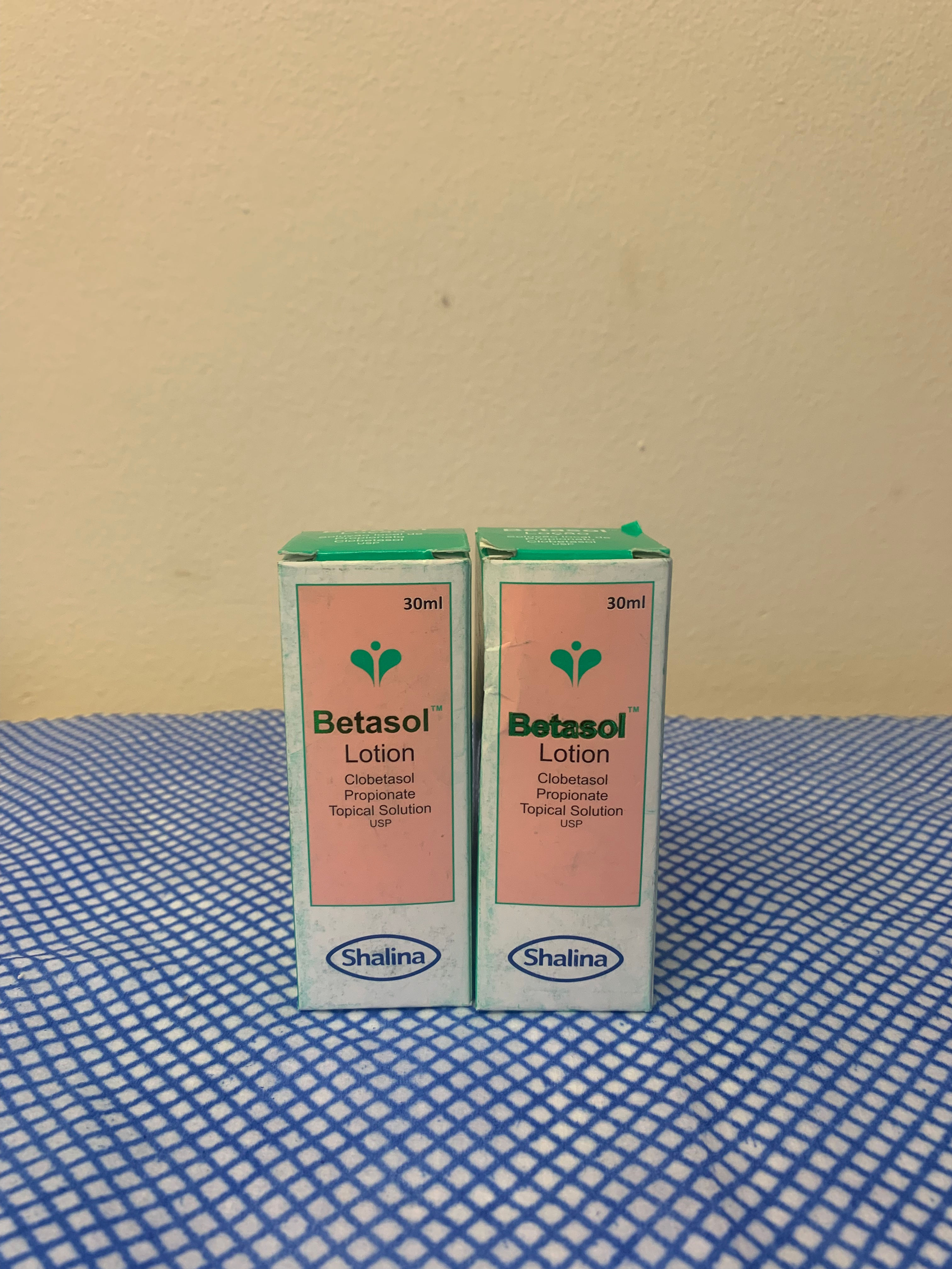 Two boxes of Betasol Lotion by Shalina on a blue cloth.