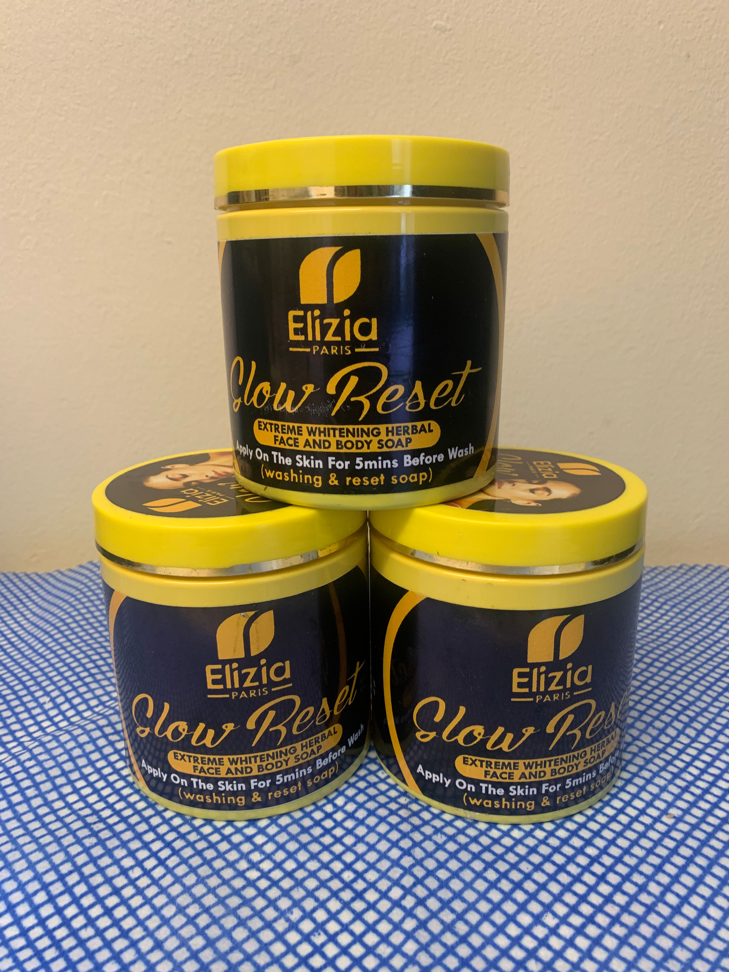 Three jars of Elizia Glow Reset serum stacked in a pyramid.