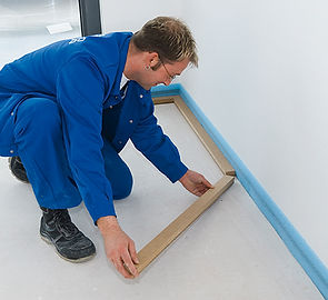 A man installs the perimeter and support battens