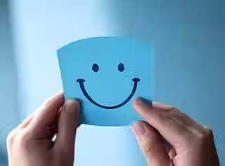 hand-holding-blue-paper-cut-happy-smile-face_941600-4288.jpg.avif