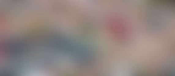 Large used car dealership lot with rows of vehicles and customers browsing