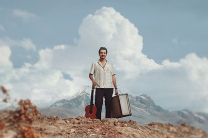 Matheus Fonseca na capa do álbum imigrante com a maleta de mão, o violão e com o fundo da cordilheira dos Andes. Compositor Viajante.