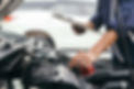 書類を見ながら検査をしている自動車整備士