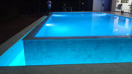 Completed infinity swimming pool overlooking a garden or landscape.