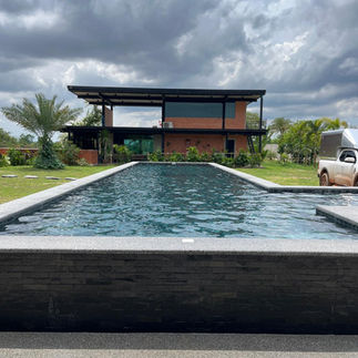 Modern overflow swimming pool with water flowing into the overflow channel