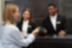 Mulher realizando o pagamento de sua estadia na recepção do hotel