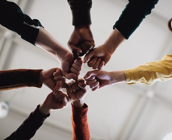 Team of people with their hands in a circle.