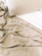 Lit habillé d’un drap en lin lavé coloris naturel, apportant une touche élégante et apaisante à la chambre
