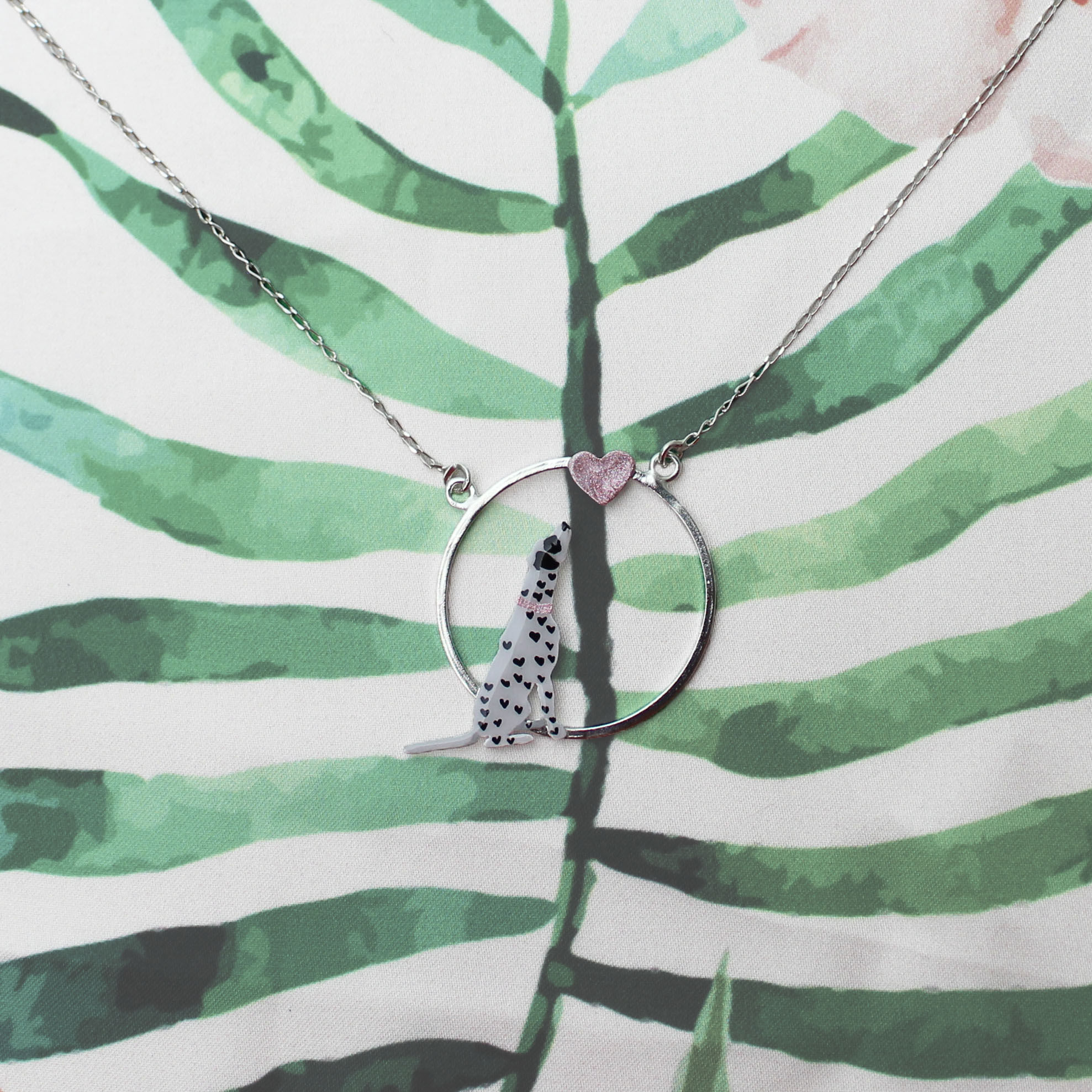 Collar de plata ley 950, el dije es de forma circular con un perro dálmata en la parte inferior derecha y un dije de corazón en la parte superior, la plata esta pintada y resinada.
