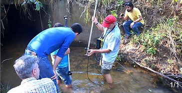 People standing in stream with technical instruments