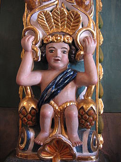 Niñño con copilli. Escultura en madera que forma parte de la ornamentación de los muros del templo. Foto: http://www.elhistoriador.mx/