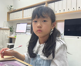 子供がタブレットを使い、真剣な表情で作業する教室風景 Kids