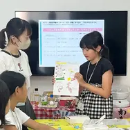 画面の前で自分の作品を発表する子どもと見守る子どもたち