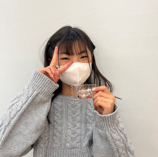 マスク姿の女の子がピースサインをして作品を手にしている