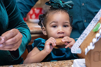 capturing a child eating a gingerbread cookie while on a gingerbread mini session photographed by pamela l king photography