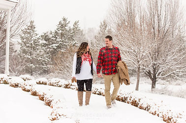 man and woman posing for maternity photos in the snow photographed by Pamela l king photography