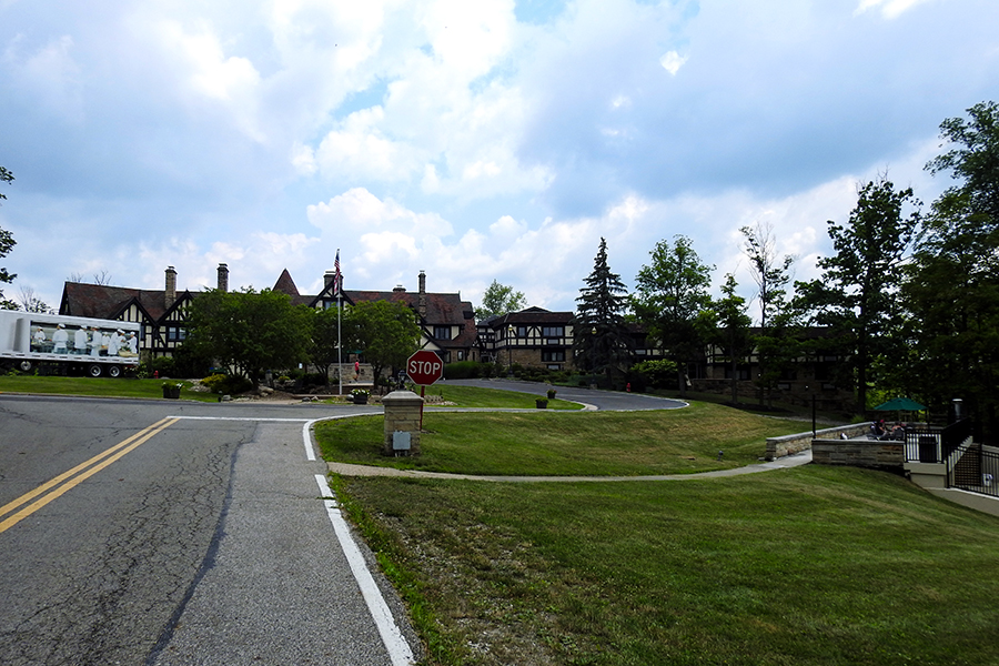 Road leading to the historic manor lodge at Punderson State Park under a partly cloudy sky.