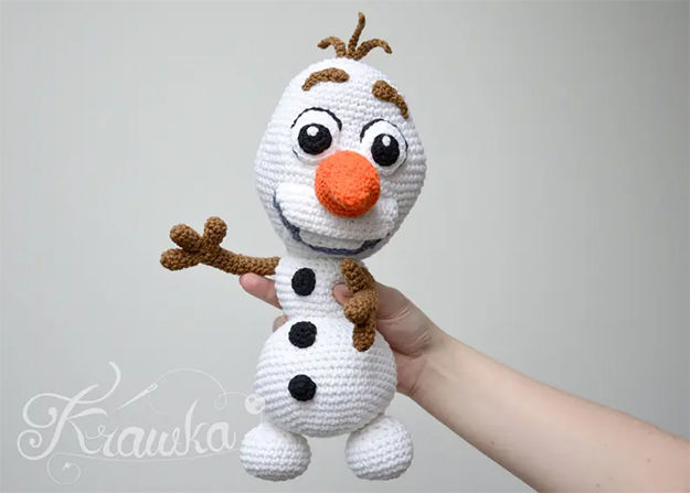 Christmas crochet pattern for amigurumi Olaf doll with carrot nose and cheerful expression.