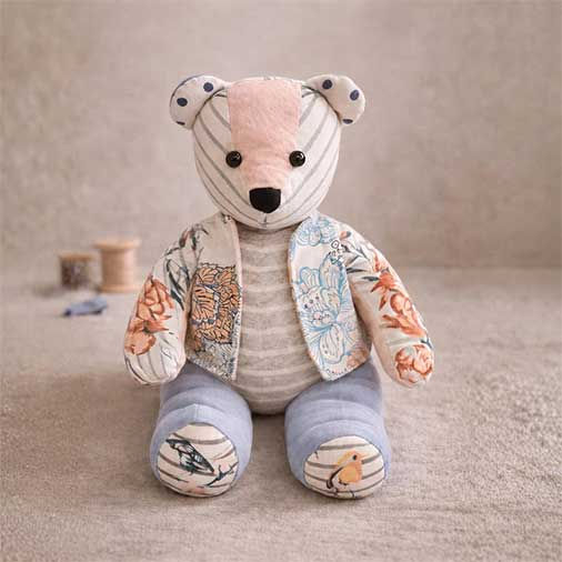 Plaid memory bear sewing pattern crafted with button details, pictured next to a jar of lavender.