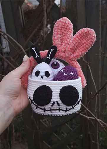 Crochet Jack Skellington bunny Easter basket with pink ears and spooky stitched skull face.
