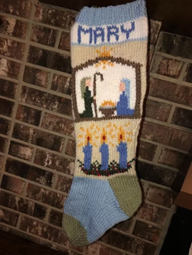 Knitted Christmas stocking with a Nativity scene design and 'Mary' name, crafted from Nativity Knitting Patterns.