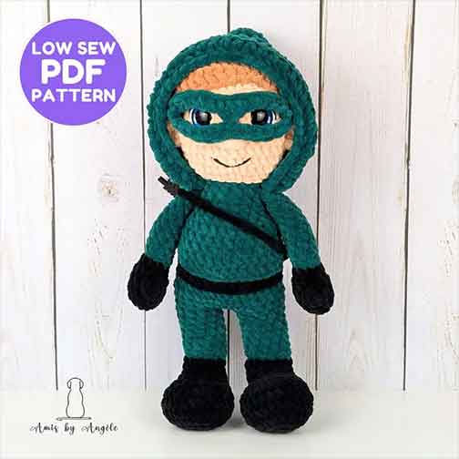 Green Arrow crochet doll in green hood and mask with bow strap, a low-sew DC Comics crochet pattern.