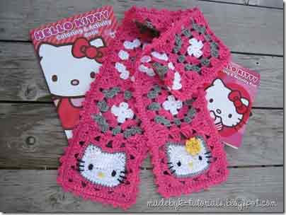 Hello Kitty crochet granny square scarf with pink floral motifs, displayed on wood surface.