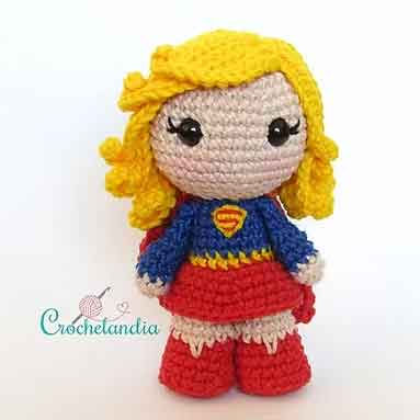 Supergirl crochet doll with blonde hair, red skirt, and cape, a cute DC Comics crochet pattern for fans.