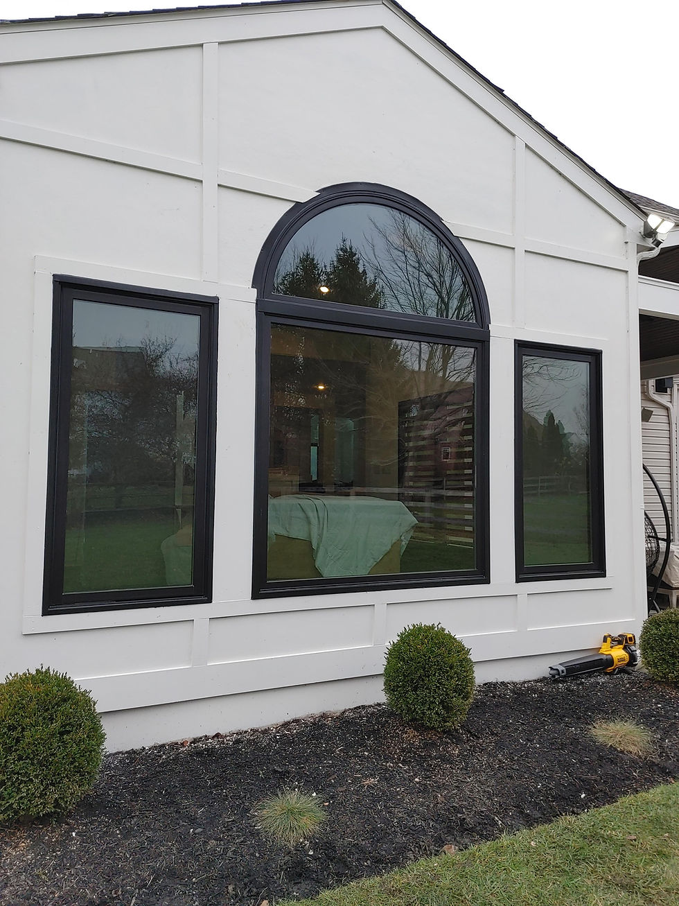 White house with new arched and rectangular window installation.