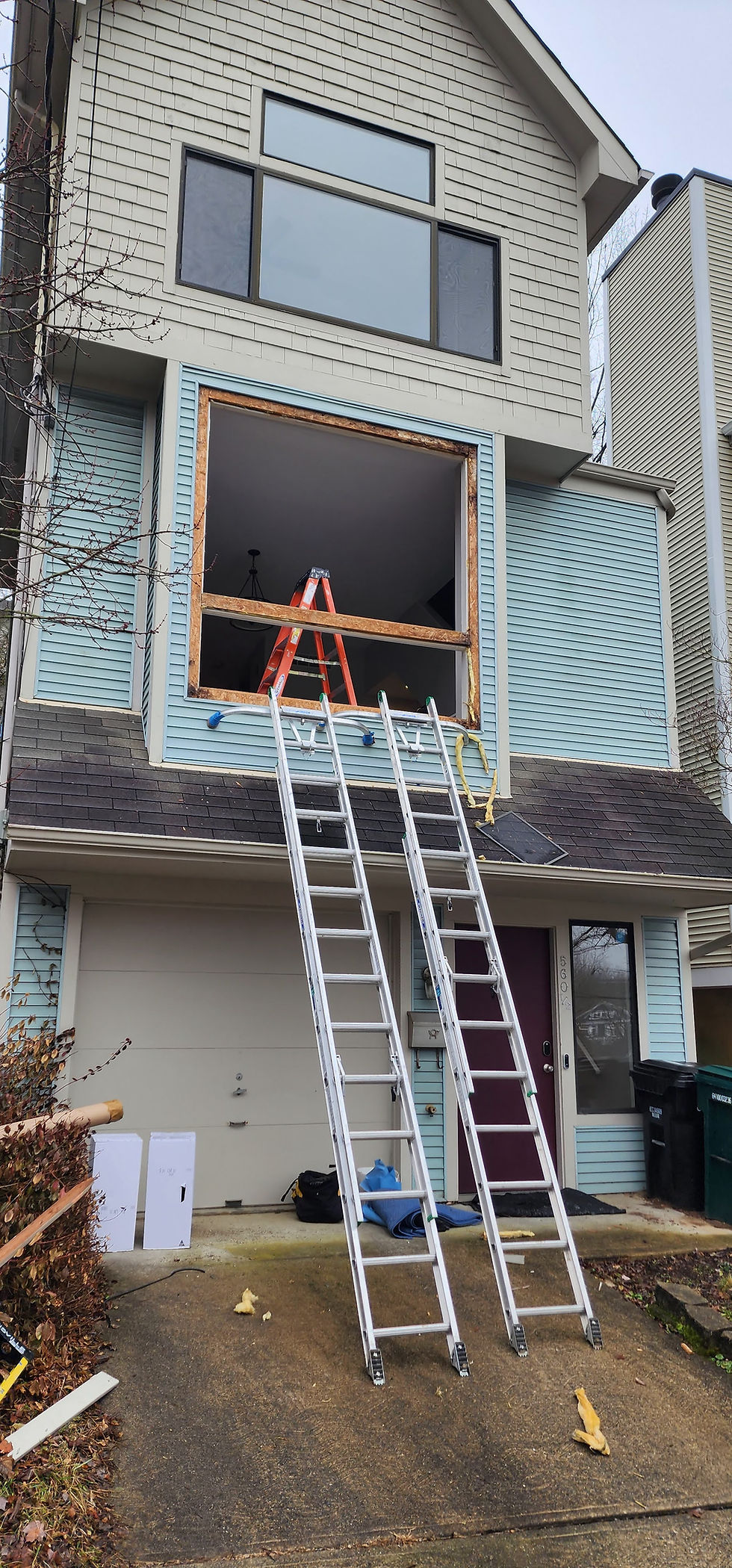 Home undergoing window and door installation services with ladders