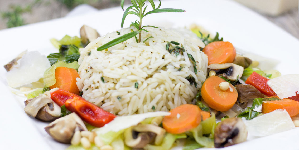 mão segurando garfo e um prato saboroso de legumes