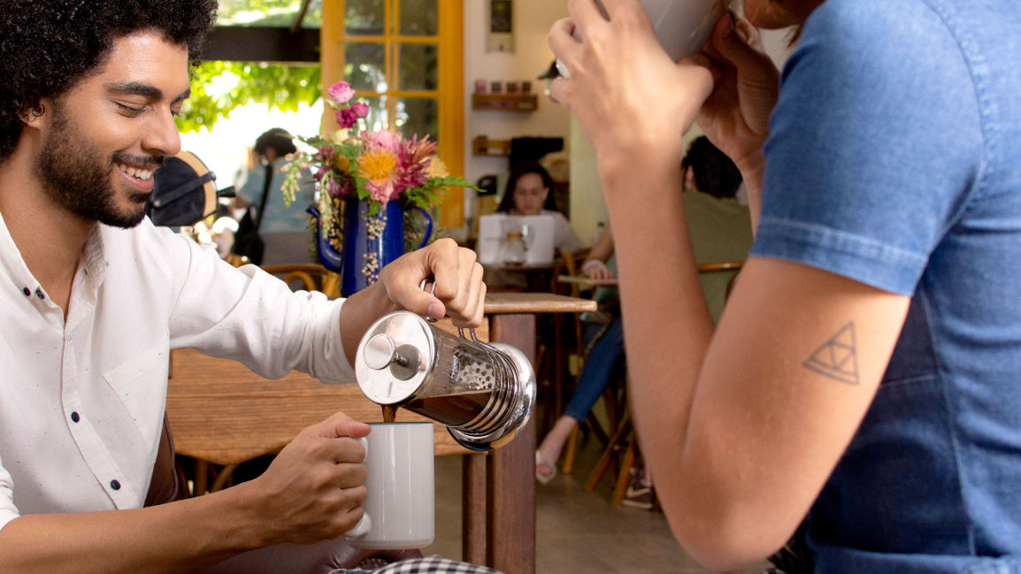 um Casal tomando café em um ambiente de trabalho