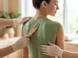 Argila verde medicinal sendo aplicada nas costas para desintoxicação de metais pesados.