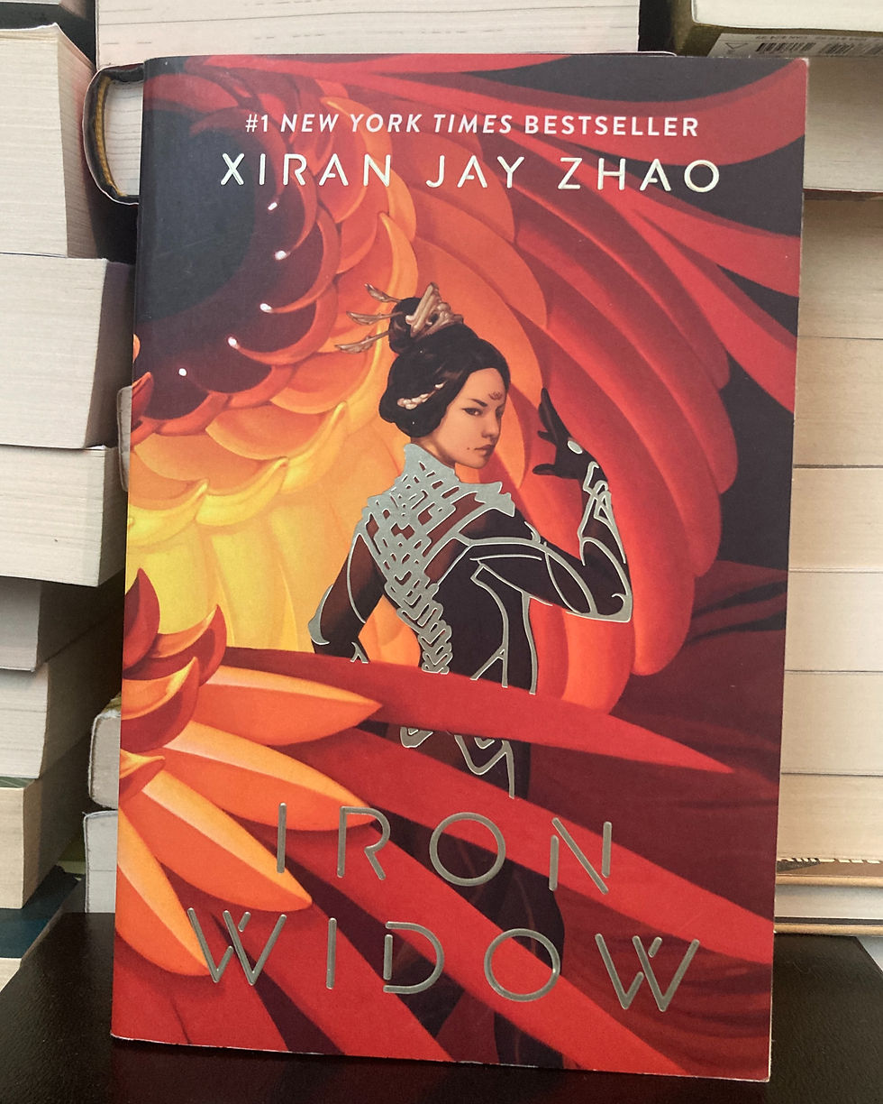 Photo of Iron Widow by Xiran Jay Zhao in paperback, in front of a stack of books