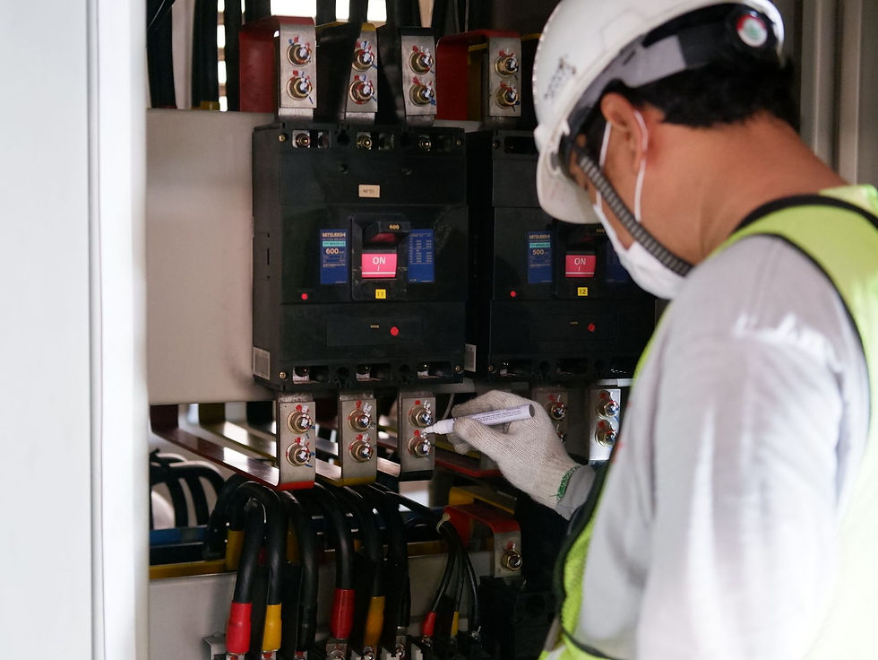 A technician in safety gear inspecting an electrical switchgear panel, part of critical facility readiness